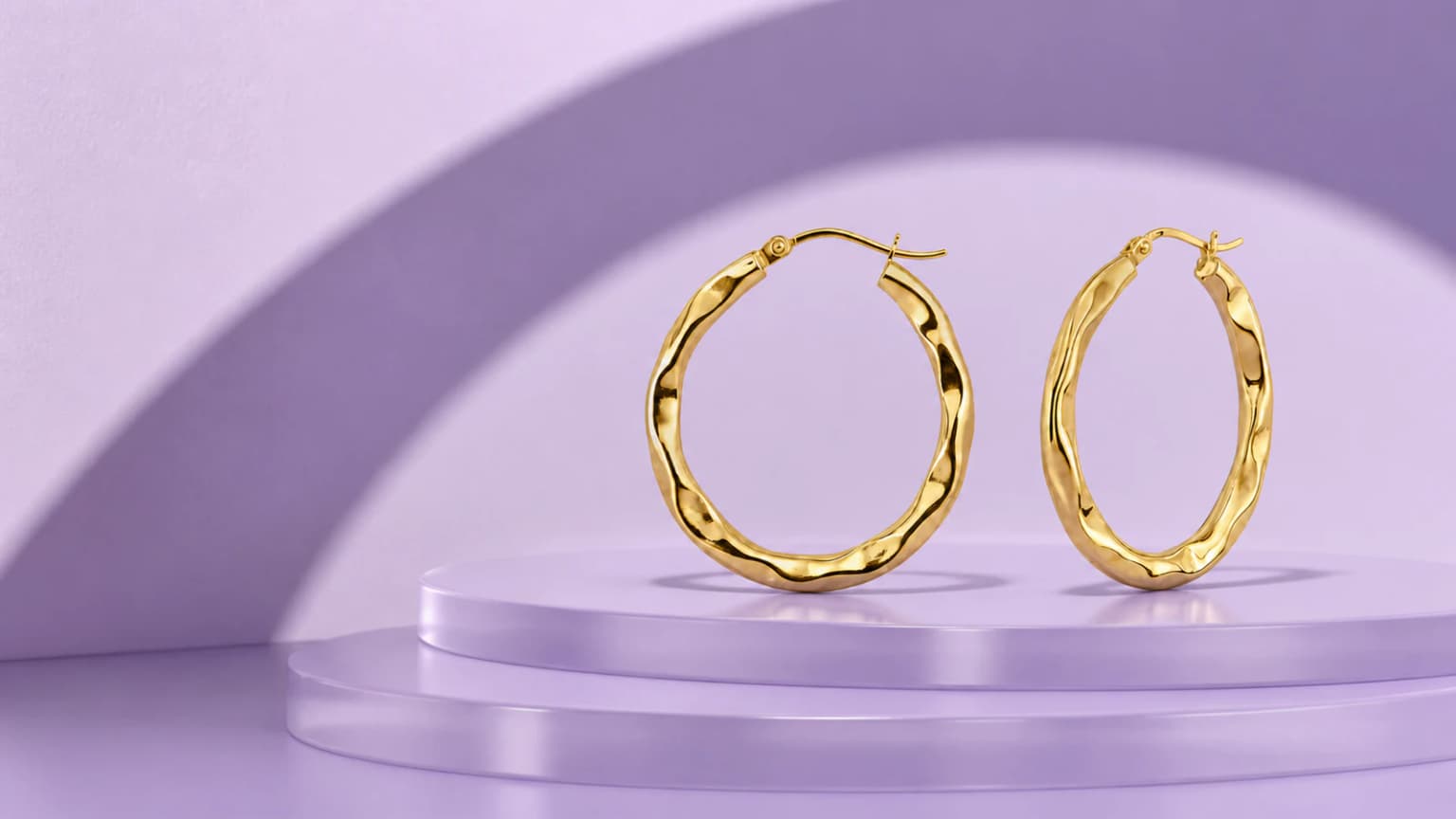 Large wavy ribbon gold hoop earrings on a lavender architectural set